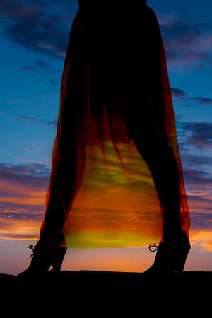 a silhouette of a woman's legs in the outdoors.