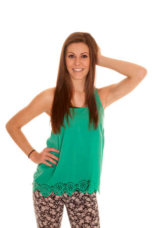 a woman in her bright green tank and flower pants with a smile on her face.の写真素材