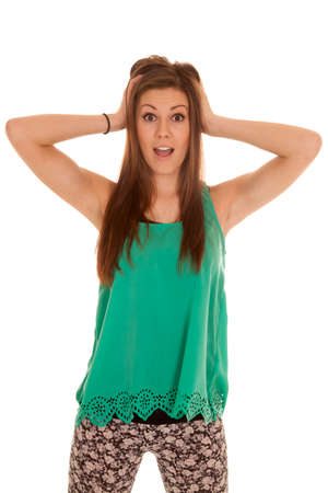 a woman with her hands in her hair with a shocked expression on her face.の写真素材