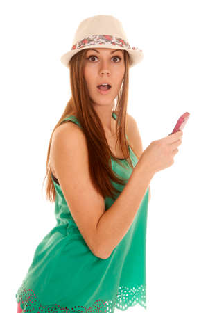 A woman with a shocked expression on her face using her phone to textの写真素材