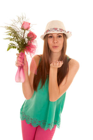 a woman holding on to roses blowing a kissの写真素材