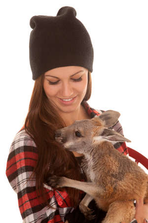 A woman in her black beanie holding on to a baby kangarooの写真素材