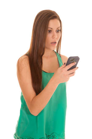 a woman reading a text on her phone with a shocked expression on her face.の写真素材