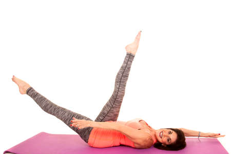 an older woman doing yoga and stretching her legs up to the sky.