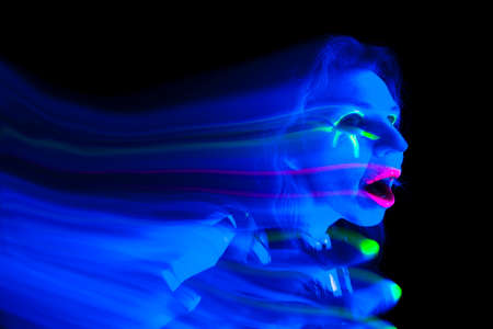A woman looks like a ghost with her hand up.の写真素材