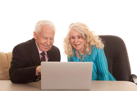 a older couple working on a laptop with smiles on thier faces.の写真素材