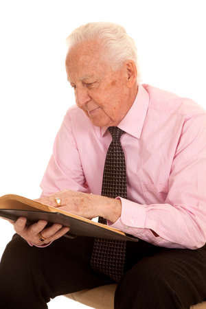 An elderly man reading and studying a book.の写真素材