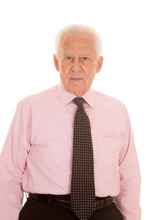 An elderly man in his pink shirt and tie looking serious.の写真素材