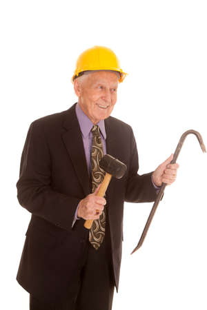 An elderly man in his construction hat and holding on to tools.の写真素材