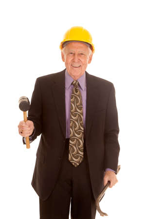 an older man in his hard hat holding on to his construction tools.の写真素材