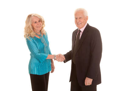 An elderly couple in their business clothing shaking hands.の写真素材
