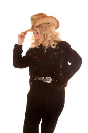 An elderly woman in her cowgirl clothing touching the brim of her hat.の写真素材