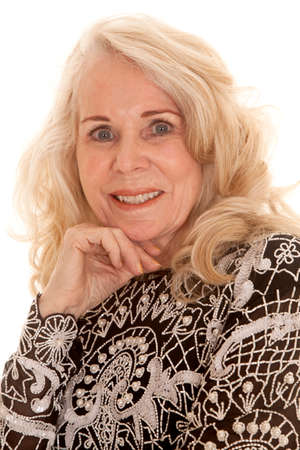 A close up of an elderly woman with her hand under her chin.の写真素材