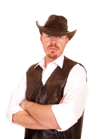 A cowboy in a vest with his arms folded and a serious expression.の写真素材