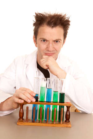 A scientist is thinking and using some test tubes with blue and green chemicals.の写真素材
