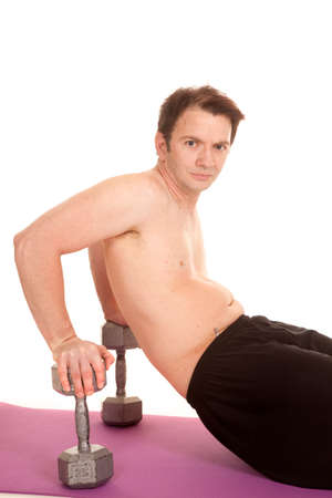 A man is sitting on weights working out.の写真素材