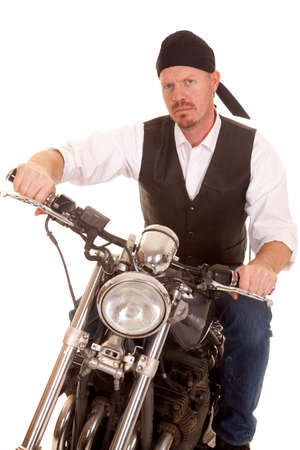 A man on a motorcycle sitting with a serious expression on his face.の写真素材