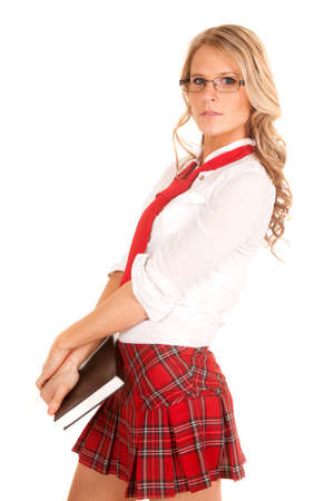 A woman in a school girl skirt with a book.の写真素材
