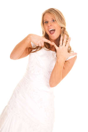 A bride in a wedding dress holding up her ring excited.の写真素材