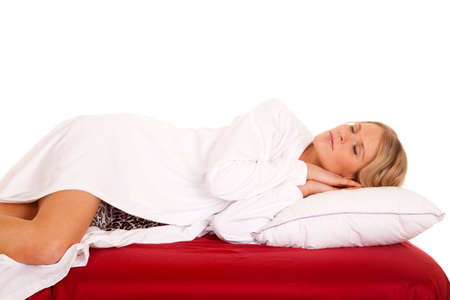 A woman in a white robe sleeping on a bed.の写真素材