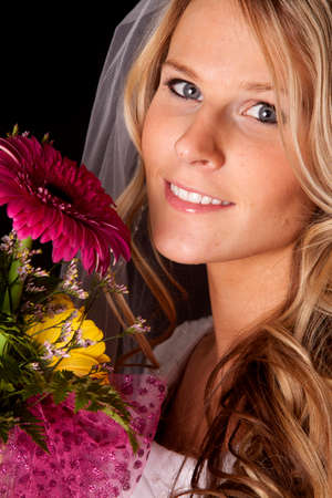 A woman in a wedding dress with a bunch of flowers.の写真素材