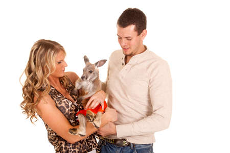 a man and woman looking down at their pet kangaroo.の写真素材
