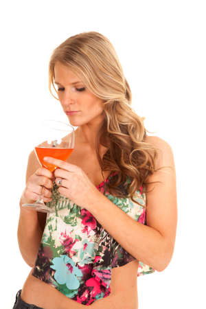a woman looking down into her wine glass.の写真素材