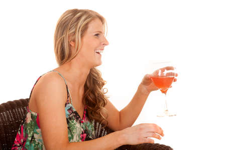 A woman laughing while holding on to her drink.の写真素材