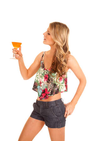 A woman holding up her wine glass looking at it.の写真素材