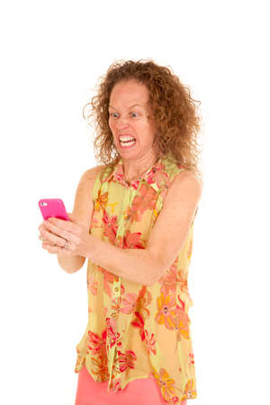 a woman holding on to her pink phone frustratedの写真素材