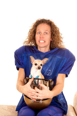 a woman football player smiling with a dog in her helmet.の写真素材