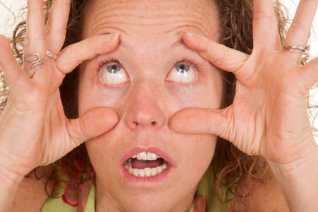 A woman trying to help her eyes open.の写真素材