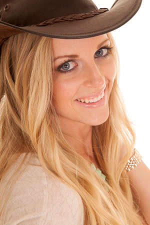 a woman with a smile on her face looking wearing a western hat.の写真素材