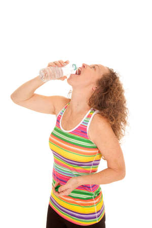 A woman in her colorful fitness tank drinking her water bottle.の写真素材