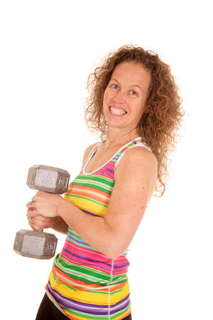 A woman with a smile on her face holding on to a big weight.の写真素材