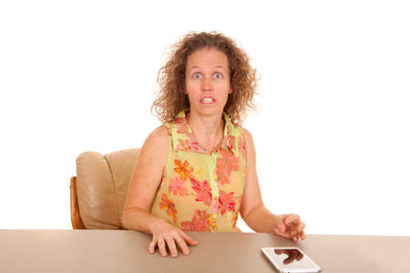 a woman with a shocked expression with her tablet on the table.