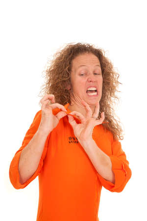 A woman inmate looking at her collar with a funny expression on her face,の写真素材