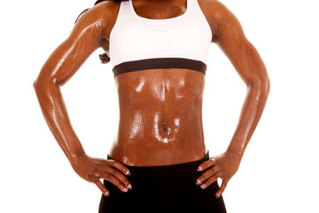 A close up of an African American with her hands on her hips standing and sweating.の写真素材