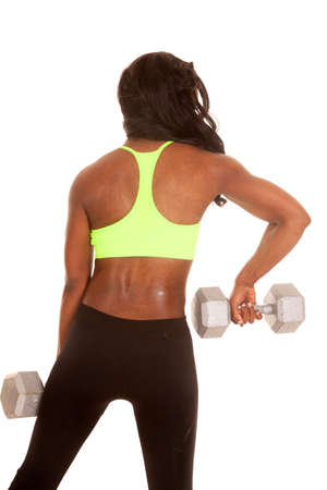 an African American woman working out with weights showing off her back.の写真素材