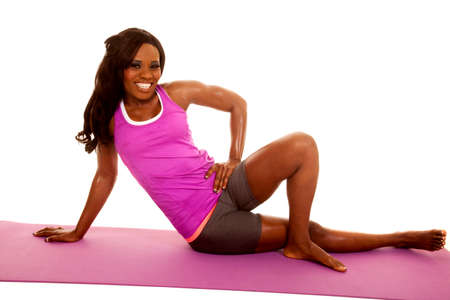 An African American sitting on her fitness mat stretching.の写真素材