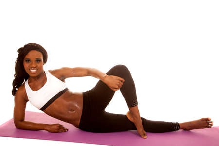 An African American laying on her side on her fitness mat, with a smile.の写真素材