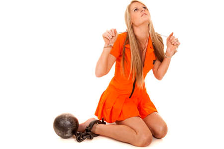 A woman in her prisoner outfit with handcuffs and a ball chain.の写真素材