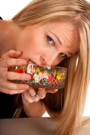 A woman putting her face in to the jelly bean bowl.の写真素材