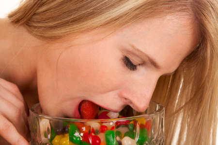 a woman with her face in the jelly bean bowl.の写真素材
