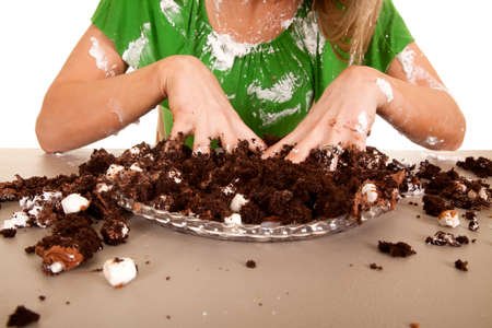 A close up of a woman with her hands in her cake.の写真素材