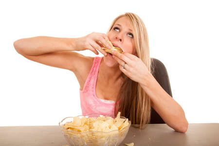 A woman shoving her face with potato chips.の写真素材