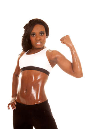 an African American woman in her fitness clothing flexing her arm.の写真素材