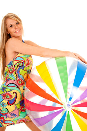 a woman holding on to a large beach ball.の写真素材