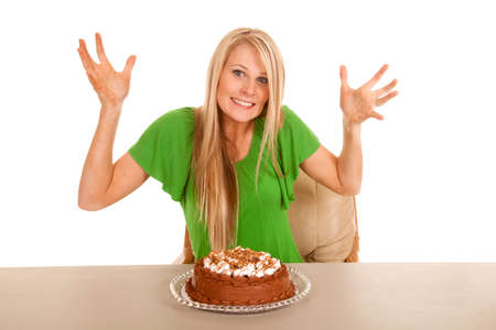 A woman with a cake on the table with her hands out and a smile on her lips.の写真素材