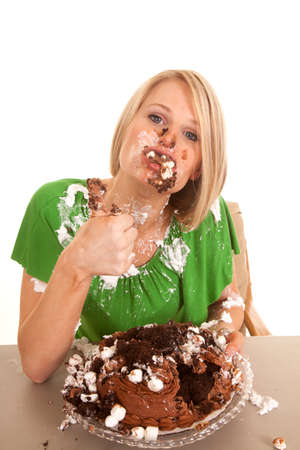 A woman with a mouthful of chocolate cake and marshmallows.の写真素材